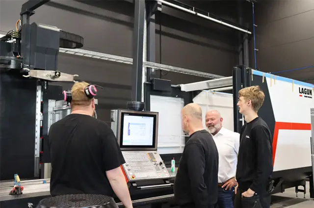 fyra män står framför en maskin